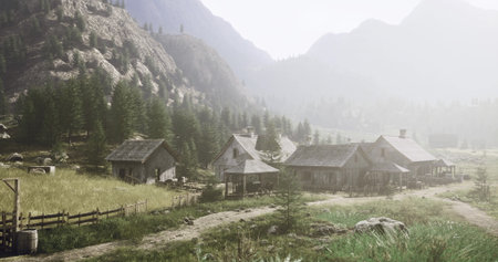 Tranquil village surrounded by lush greenery and mountains during the early morning. Houses made of wood are scattered around, with a pathway leading through the landscape.の写真素材