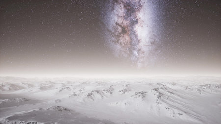Cold, serene snow covered mountains stretch endlessly beneath a vibrant, starry sky. The Milky Way shines brightly, creating a stunning cosmic backdrop that captivates the imagination.の写真素材