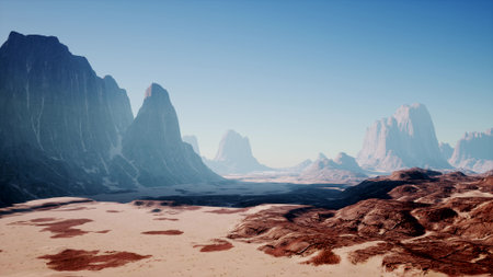 A breathtaking view features towering mountains rising dramatically in the background, while a vast, arid expanse of desert sprawls in the foreground. The clear sky casts a tranquil atmosphere.の写真素材