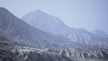 Vast, rugged mountains stretch across the landscape, their peaks obscured by a gentle mist. The scene captures a serene and quiet atmosphere, inviting exploration and wonder.の写真素材