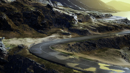 A winding road curves through rugged mountains, surrounded by rocky cliffs and patches of grass. The...