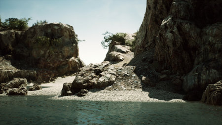 A serene coastal view reveals a rocky shoreline where sunlight dances on clear water. The rugged cliffs frame the peaceful scene, inviting exploration and relaxation.の写真素材