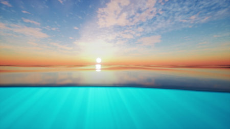 A breathtaking view captures the moment when the sun sets over a calm ocean, creating vibrant hues of orange and blue. Soft waves reflect the beautiful sky as day turns to night.の写真素材