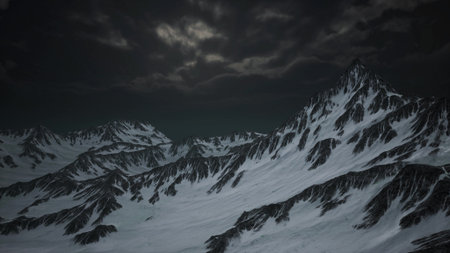 Towering mountains covered in pristine snow rise against a dark, cloudy sky. The atmosphere is tranquil yet eerie, creating a captivating and serene winter landscape.の写真素材