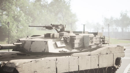 A military tank stands on a quiet street, surrounded by trees and soft light. The tanks surface is rugged, showcasing its battle worn texture while casting shadows on the pavement.の写真素材