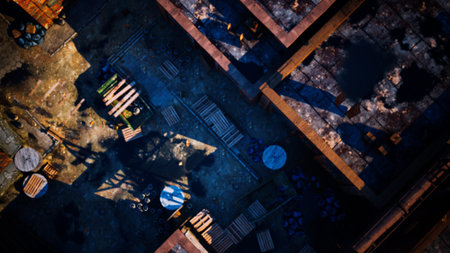 From above, the bustling scene shows tables and scattered goods as shadows dance in a golden glow of late afternoon light, capturing the essence of vibrant life.の写真素材