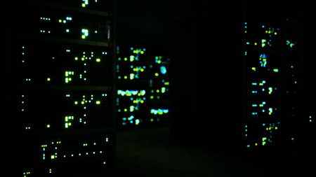 Sets of glowing lights flicker in a dimly lit server room. The vibrant blues and greens create a mesmerizing display, hinting at the ongoing data processing within machines.の写真素材