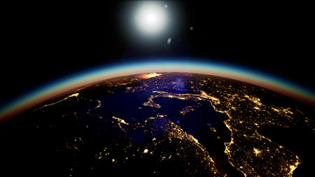 A stunning view of Earth at night reveals cities twinkling with lights as the sun begins to rise.の写真素材
