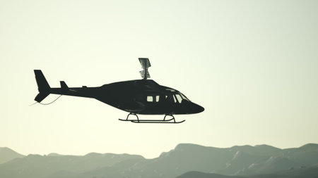 A black helicopter soars high in the sky, silhouetted against the fading light of sunset. The mountains create a serene backdrop, blending with the changing colors of the evening.の写真素材