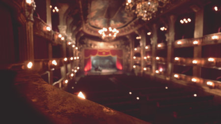The grand theater glows softly with warm lights illuminating its stunning architecture. An audience awaits as the stage is set for an enchanting evening of performance and creativity.の写真素材