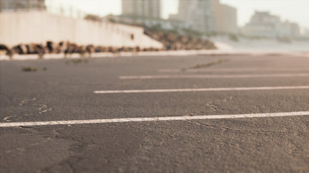 Calm evening at a coastal parking lot where the sun sets, casting golden light across the faded asphalt.の写真素材