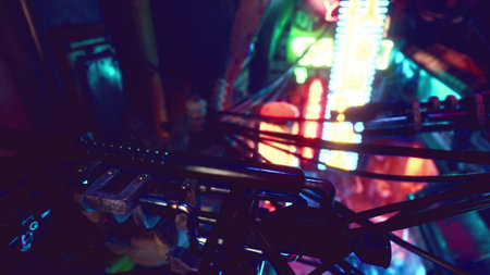 Colorful neon signs illuminate a bustling urban scene at night. Intricate power lines crisscross above, adding an element of chaos to the lively atmosphere.の写真素材