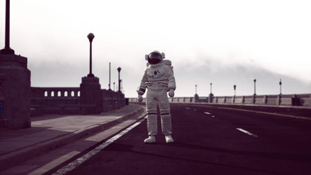 An astronaut stands alone on a deserted road, surrounded by a hazy atmosphere. The early morning light casts a mysterious glow, creating an intriguing scene of isolation and wonder.の写真素材