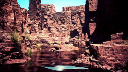 Bright sunlight illuminates a stunning canyon filled with unique rock formations. Calm water...