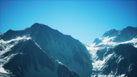 Snow covered mountains rise dramatically against a clear blue sky. The scene captures the tranquility and beauty of a winter landscape, inviting exploration and adventure.の写真素材