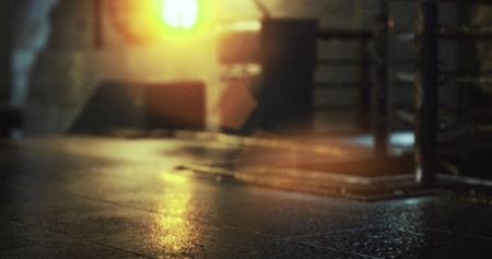 Sunlight filters through an opening in an industrial setting, casting warm light on a wet surface. The surroundings feature metal equipment and unfinished walls, creating a nostalgic atmosphere.の写真素材