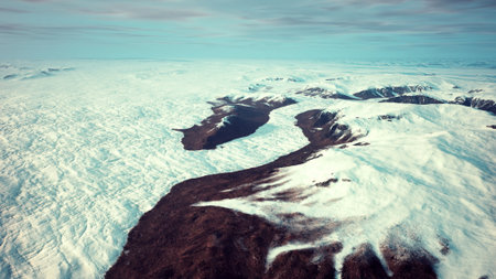 Snow blankets the vast landscape as sunlight glimmers off the glaciers. Rocky peaks rise dramatically, showcasing natures beauty in a remote and tranquil wilderness.の写真素材