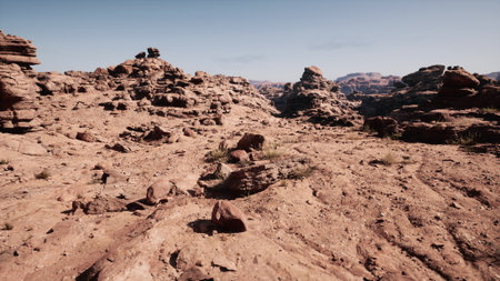 Vast rocky formations stretch across the arid landscape, illuminated by bright sunlight. Sparse vegetation and rugged terrain create a breathtaking scene of natures beauty.の写真素材