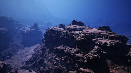 Bright blue water envelops rocky underwater formations, revealing a stunning world. Sunlight pierces the surface, illuminating the rocky terrain and creating a tranquil atmosphere.の写真素材