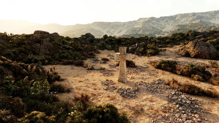 An ancient stone cross rises in the center of a dry expanse, surrounded by rugged rocks and sparse vegetation. The golden light of sunset casts long shadows over the serene landscape.の写真素材