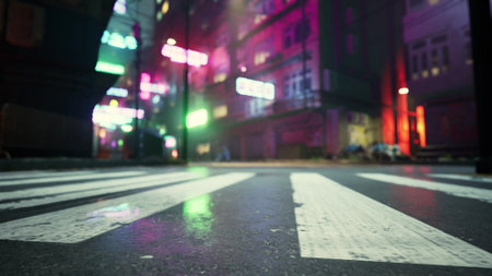 Colorful neon signs cast an electric glow over a lively urban alley as night descends. The wet pavement reflects the bright lights, creating a vibrant atmosphere filled with energy and life.の写真素材