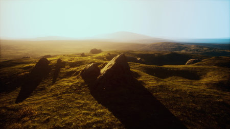 Warm light blankets the landscape as the sun sets behind distant hills. Shadows stretch across...