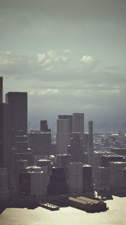 Breathtaking view of a modern city skyline during dusk, with towering buildings reflecting in the serene waters below. The sky is filled with soft clouds creating a peaceful atmosphere.の写真素材