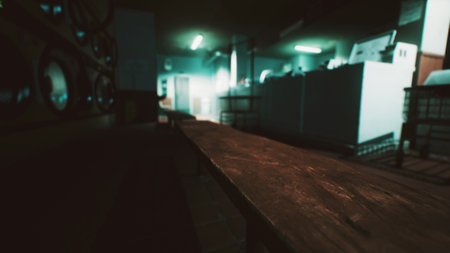A dimly lit laundry room features a long wooden table with fluorescent green lights illuminating the space. The atmosphere feels mysterious and slightly unsettling, inviting curiosity.の写真素材