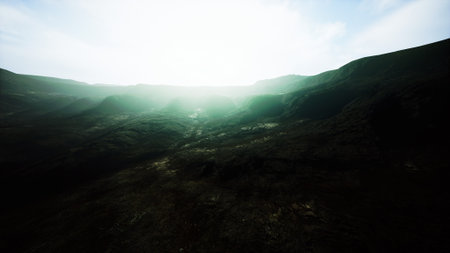 Golden light spills over the rugged landscape, revealing a dramatic valley surrounded by towering...