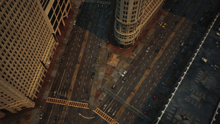 The evening sky is painted in warm tones as sunlight reflects off towering buildings. Cars navigate busy intersections, creating a lively atmosphere in the heart of the city during twilight.の写真素材