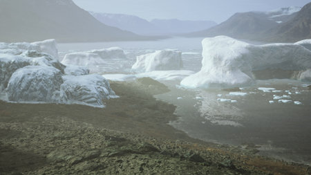 Calm waters reflect large icebergs as they drift in an Arctic bay. Soft light bathes the scene,...