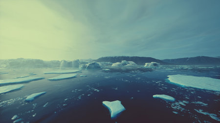 A serene scene unfolds with large icebergs drifting in deep blue waters under a soft twilight sky. The peaceful atmosphere showcases natures icy wonders and the vastness of the Arctic.の写真素材
