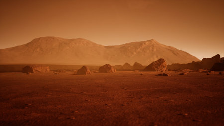 Barren terrain stretches across the surface of Mars, with rugged mountains rising in the background. Rocks dot the dusty ground as the orange light of twilight casts shadows across the landscape.の写真素材