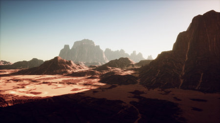 Warm light bathes the vast desert, highlighting the rugged peaks and valleys. Shadows stretch across the sandy terrain as the sun dips, creating a tranquil atmosphere perfect for exploration.の写真素材
