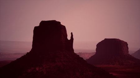 Sunsets cast a warm glow over the dramatic buttes of Monument Valley, highlighting their unique...
