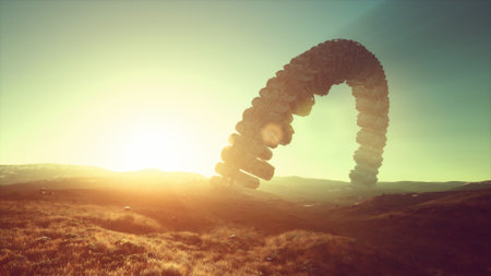 Golden sunlight bathes the landscape as a strange, towering structure catches the eye. Rolling hills provide a serene backdrop, creating a surreal atmosphere in natureâs beauty.の写真素材