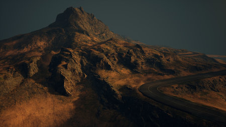 An enchanting mountain road curves gently through rugged terrain as soft twilight illuminates the rocky peaks. The rich hues of the earth contrast with the evening sky, creating a serene atmosphere.の写真素材