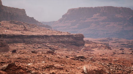 Expansive red rock formations create a breathtaking view in a remote desert area. The hazy sky adds a mystical atmosphere, highlighting natures raw beauty and solitude.の写真素材