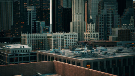 High above the bustling city, the sunset casts a warm glow on the intricate faÃ§ade of towering skyscrapers. Rooftops shimmer in the evening light as the day fades away.の写真素材