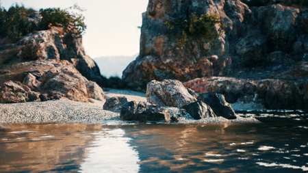 Bright sunlight filters down on a tranquil lake surrounded by rugged rocks and gentle waves. The scenery offers a peaceful escape into natures beauty, ideal for relaxation.の写真素材