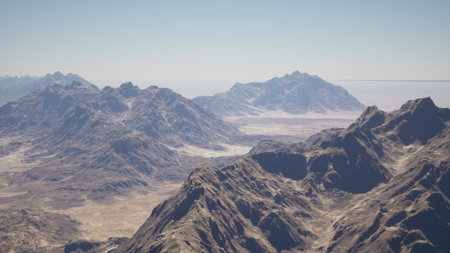 Vast mountain ranges rise dramatically under a brilliant blue sky. The sun casts shadows over the rugged terrain, revealing intricate details and the beauty of untouched nature.の写真素材