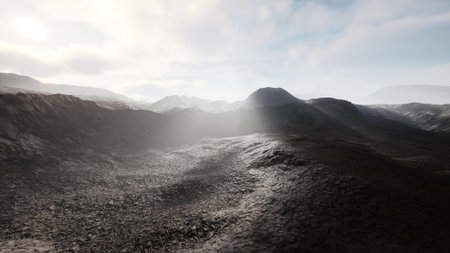 Expansive view of rugged, rocky terrain with gentle hills and deep shadows. The scene is illuminated by soft sunlight breaking through scattered clouds, creating an ethereal atmosphere.の写真素材