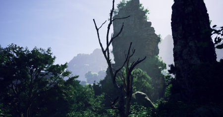 Lush greenery surrounds towering rocky formations in a mountainous area during daylight. The vibrant vegetation contrasts with the rugged landscape, creating a serene natural view.の写真素材