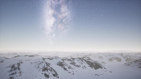 Majestic snow covered peaks stretch across the horizon, as a breathtaking display of stars fills the sky. The serene atmosphere evokes a sense of wonder and tranquility at dusk.の写真素材