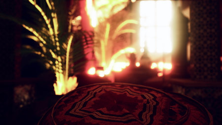 A soft glow of light fills a Moroccan space at dusk, highlighting ornate textiles and lush greenery. The atmosphere is inviting and tranquil, perfect for relaxation and reflection.の写真素材