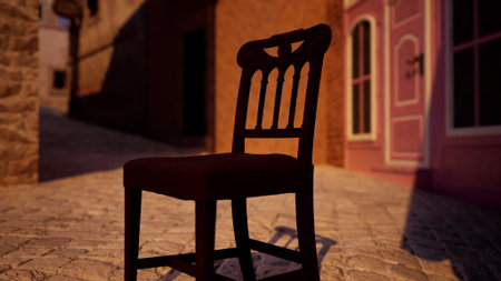 A solitary chair sits on cobblestones, casting a gentle shadow under the warm sun. Surrounding buildings with rustic facades create a charming village atmosphere, evoking a sense of tranquility.の写真素材