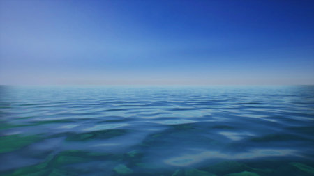 Gentle waves ripple across a vast body of water, reflecting the vibrant blue sky. The scene evokes a sense of peace and tranquility on a warm summer afternoon.の写真素材