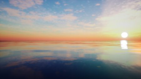 Bright sun sets over a tranquil ocean, creating a stunning display of colors in the sky and mirrored in the still waters. The atmosphere is peaceful and calming as day transitions to night.の写真素材