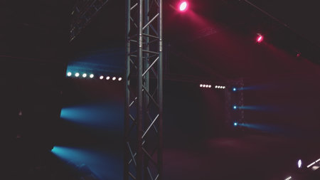 Bright stage lights create a captivating ambiance in a performance venue. The beams of light shine in various colors, enhancing the excitement of the evening event.の写真素材