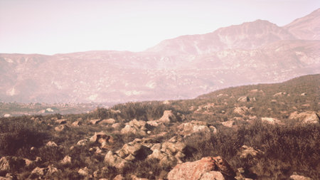 Soft sunlight illuminates a rocky landscape in the mountains. Rolling hills and distant peaks create a serene atmosphere, inviting exploration of natures beauty and tranquility.の写真素材